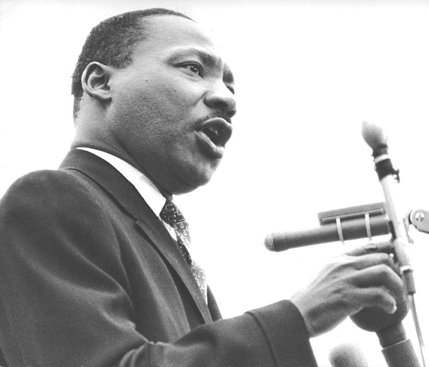 Dr. Martin Luther King, Jr. using a microphone.